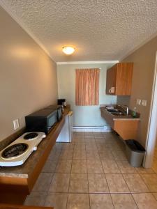 a small kitchen with a counter with a microwave at Aspen Motor Inn in Drayton Valley