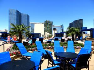 un ensemble de chaises et de tables bleues sur une terrasse dans l'établissement Polo Towers by Raintree, à Las Vegas