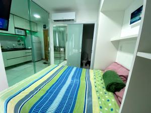 sypialnia z kolorowym łóżkiem w pokoju w obiekcie Smart Itapuä w mieście Salvador