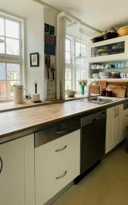 uma cozinha com armários brancos e um balcão de madeira em ApartmentInCopenhagen Apartment 134 em Copenhague