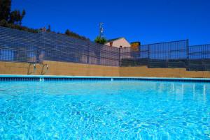 a swimming pool with blue water in front of a fence at Best 5 Motel in Salinas