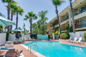 a swimming pool with chairs and a turtle next to a building at Hotel Pepper Tree Boutique Kitchen Studios - Anaheim in Anaheim