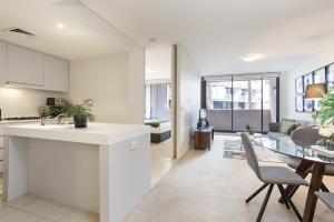 a kitchen and living room with a table and chairs at Darling Harbour Apartment near King St Wharf in Sydney