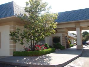 a house with a tree and flowers in front of it at American Inn North Kansas City in Kansas City