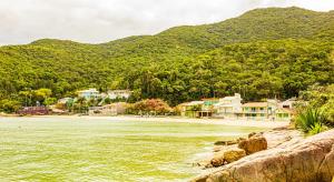 a town next to a river with mountains in the background at Pousada Casa do Oscar in Governador Celso Ramos