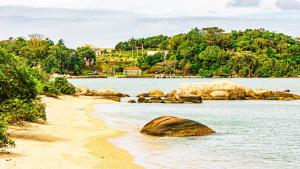 a beach with some rocks in the water at Pousada Casa do Oscar in Governador Celso Ramos