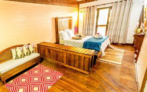 a bedroom with a bed and a bench in a room at Pousada Casa do Oscar in Governador Celso Ramos