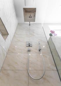 a shower in a bathroom with a tile floor at Ferienwohnung Yilmaz in Bruck an der Großglocknerstraße
