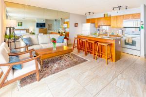 ein Wohnzimmer und eine Küche mit einem Sofa und einem Tisch in der Unterkunft Ocean View Delight, Walk to Beach with Free Parking in Honolulu