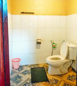 a bathroom with a toilet in a tiled room at Villa Sindoro Village in Wonosobo