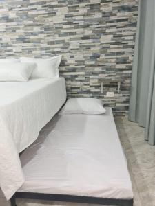 um quarto com 2 camas e uma parede de tijolos em Apartamento Turistico Soul em La Loma