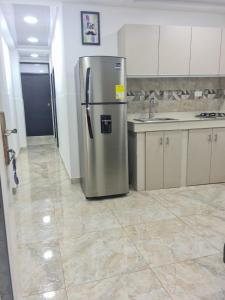 uma cozinha com um frigorífico de aço inoxidável num quarto em Apartamento Turistico Soul em La Loma