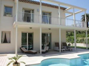 a house with a balcony and a swimming pool at Enticing villa in Juan les Pins near the beach in Juan-les-Pins