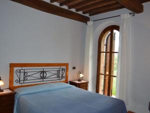 a bedroom with a bed and a large window at Belvilla by OYO Appartamento Dante in Serre di Rapolano