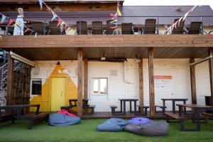 a building with a deck with three bean bags on the ground at Ays Club Sheregesh in Sheregesh