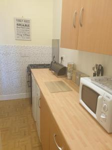 a kitchen with a counter top with a microwave at Troon Beach Town Golf Apartment Troon Ayrshire in Troon