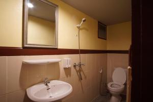 ein Badezimmer mit einem Waschbecken, einem WC und einem Spiegel in der Unterkunft Gap's house in Chiang Mai