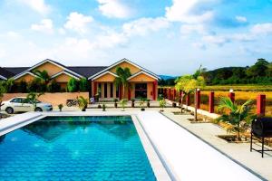 uma casa com piscina em frente a uma casa em Nahdhoh Langkawi Resort em Pantai Cenang