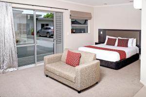 una camera con un letto, una sedia e un letto di 37 The Landing Motel a Whakatane