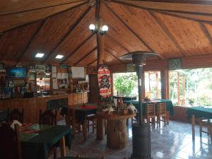 um restaurante com tectos e mesas e cadeiras de madeira em Las Cataratas Lodge em San Gerardo de Dota