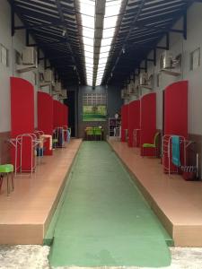 an empty room with a green floor and red dividers at Homestay dan Kost 78 in Jepara
