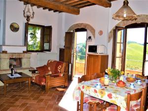 salon ze stołem i kominkiem w obiekcie Holiday Apartment Close to Asciano w mieście Asciano +37 zdjęć
