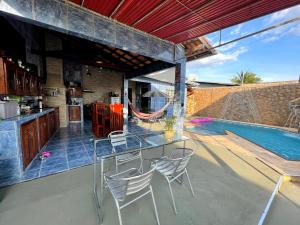 a patio with a table and chairs next to a swimming pool at Casa Galaxy in Boa Vista