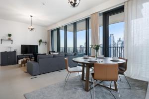 een woonkamer met een tafel en een bank bij Breathtaking City Views From DT Apt with Terrace in Dubai