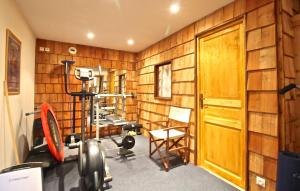 una palestra con pannelli in legno, un tapis roulant e una sedia di Odalys Chalet Mountain lodge a Les Deux Alpes