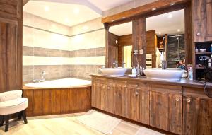 un bagno con due lavandini, una vasca e un tubermott di Odalys Chalet Mountain lodge a Les Deux Alpes