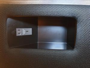 a reflection of a electrical outlet in a metal object at Cabin & Capsule Hotel J-SHIP Osaka Namba in Osaka