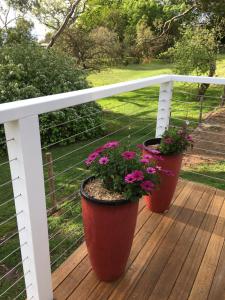 
a flower pot sitting on top of a wooden fence at STUDIO ECHUNGA Adelaide Hills in Echunga
