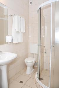 y baño con aseo, lavabo y ducha. en Hotel Terra, en Oradea