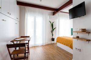 Dormitorio con escritorio, cama y TV en BeHouse Campana, en Sevilla