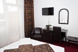 a bedroom with a desk and a chair and a mirror at Hotel Terra in Oradea