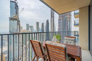 een balkon met een tafel en stoelen en een skyline van de stad bij Breathtaking City Views From DT Apt with Terrace in Dubai