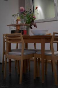 a dining room table with two chairs and a table with flowers at Superb City Apartement/studio in Luxembourg
