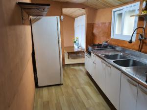 a kitchen with a white refrigerator and a sink at Hamdeok Saeya Saeya Entire House in Jeju