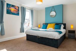 a bedroom with a large bed with blue walls at Cheltenham-2 Bed House-Sleep 6-Parking-Garden-Wifi in Cheltenham