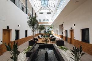ein großer Saal mit Pool in der Mitte eines Gebäudes in der Unterkunft Guadalupe 15 by Magno Apartments in Sevilla