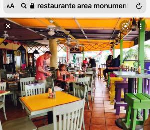 un hombre de pie en un restaurante con gente sentada en las mesas en 7DR Apt in Prime Location Near Monumental Area, en Santiago de los Caballeros