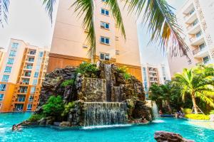 uma cascata na piscina num resort com edifícios em Atlantis Residence em Praia de Jomtien