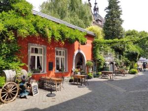 a red building with tables and chairs in front of it at Haus Christine in Traben-Trarbach in Traben-Trarbach