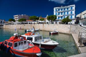 three boats are docked in the water near a building at Argonaftis Spetses in Spetses