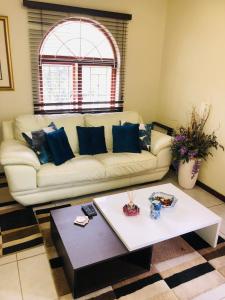 a living room with a couch and a coffee table at Lovely self catering first floor apartment in Roodepoort