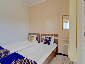 Un pat sau paturi într-o cameră la SUPER OYO 90622 Hotel Galaksi
