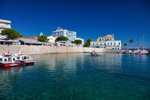 two boats are docked in a body of water with buildings at Aria Apartments in Spetses