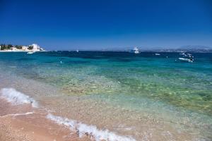 a beach with the ocean and boats in the water at Aria Apartments in Spetses