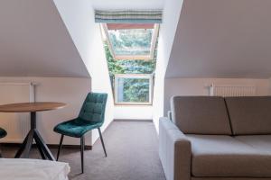 ホイニツェにあるHotel Odejewscyのリビングルーム(ソファ、テーブル付)、窓が備わります。