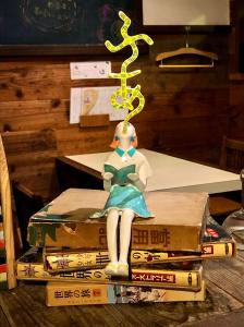 a figurine of a woman sitting on a stack of books at Onomichi Guest House Anago-no-Nedoko in Onomichi